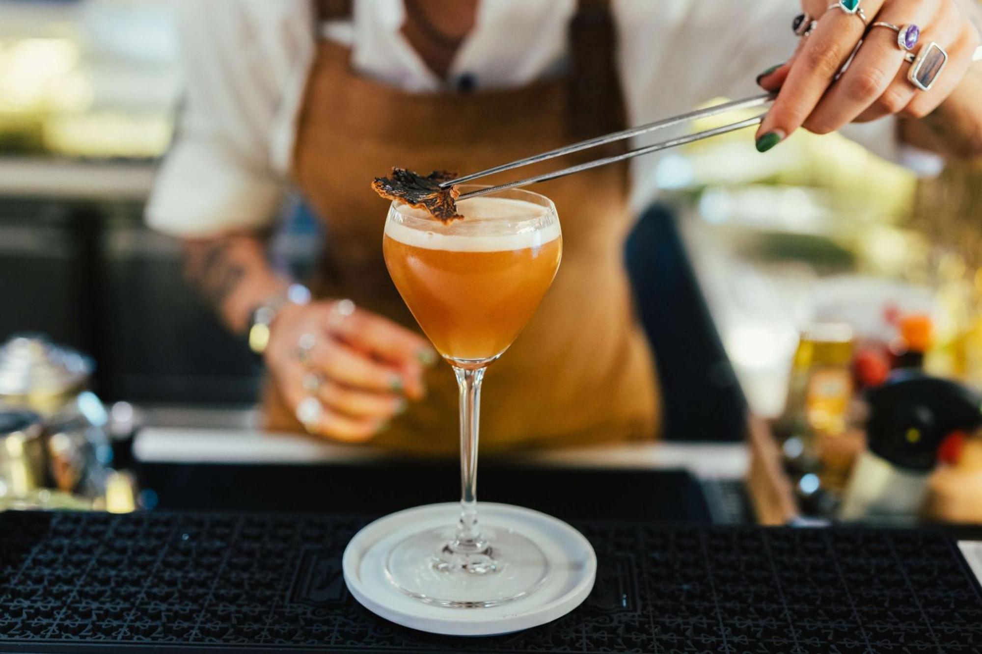 Hotel Hilton Vienna Plaza Esterno foto A bartender adding a garnish to a cocktail
